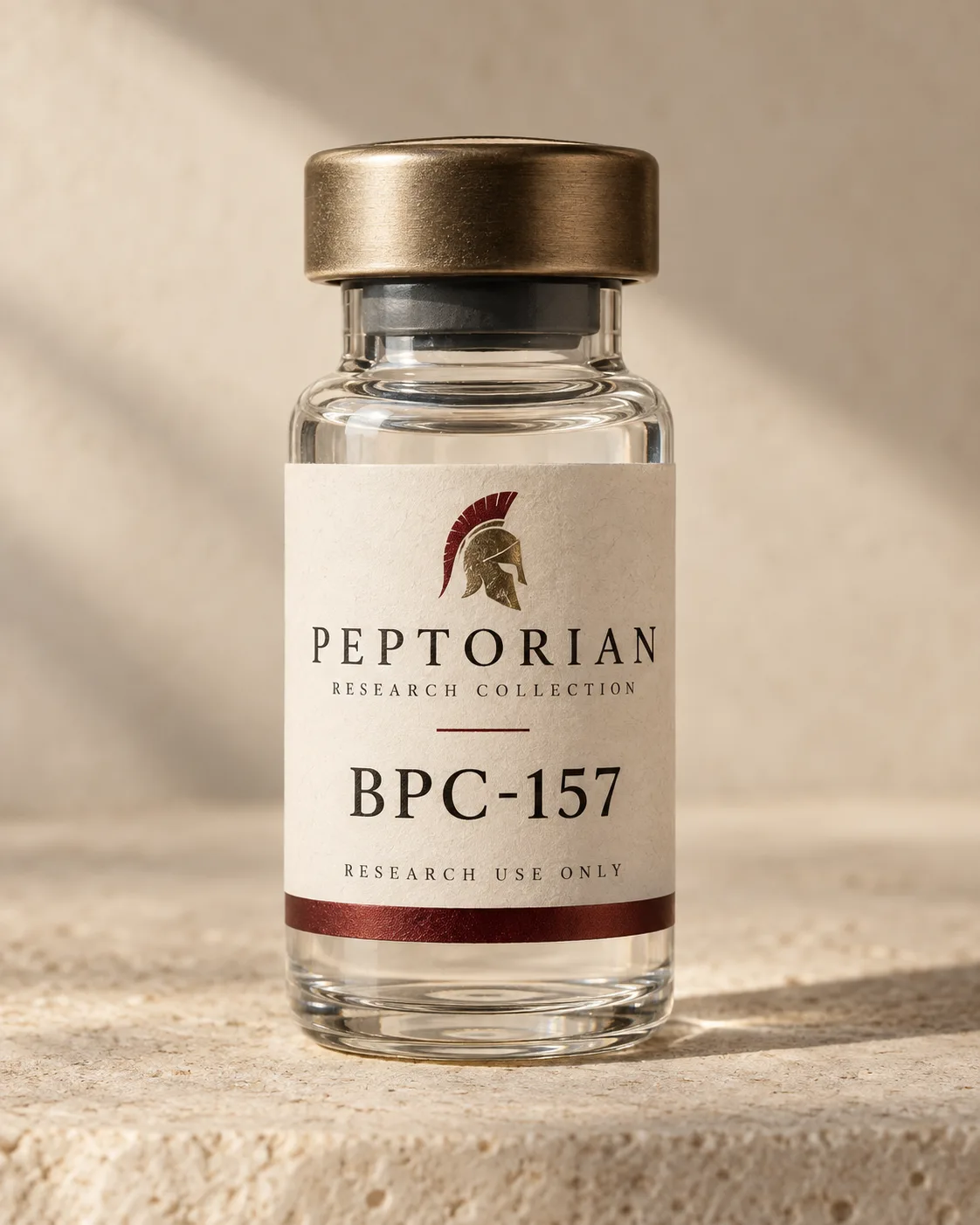 Peptorian BPC-157 research vial with a bronze cap and an ivory label showing the helmet emblem, on pale stone in warm window light